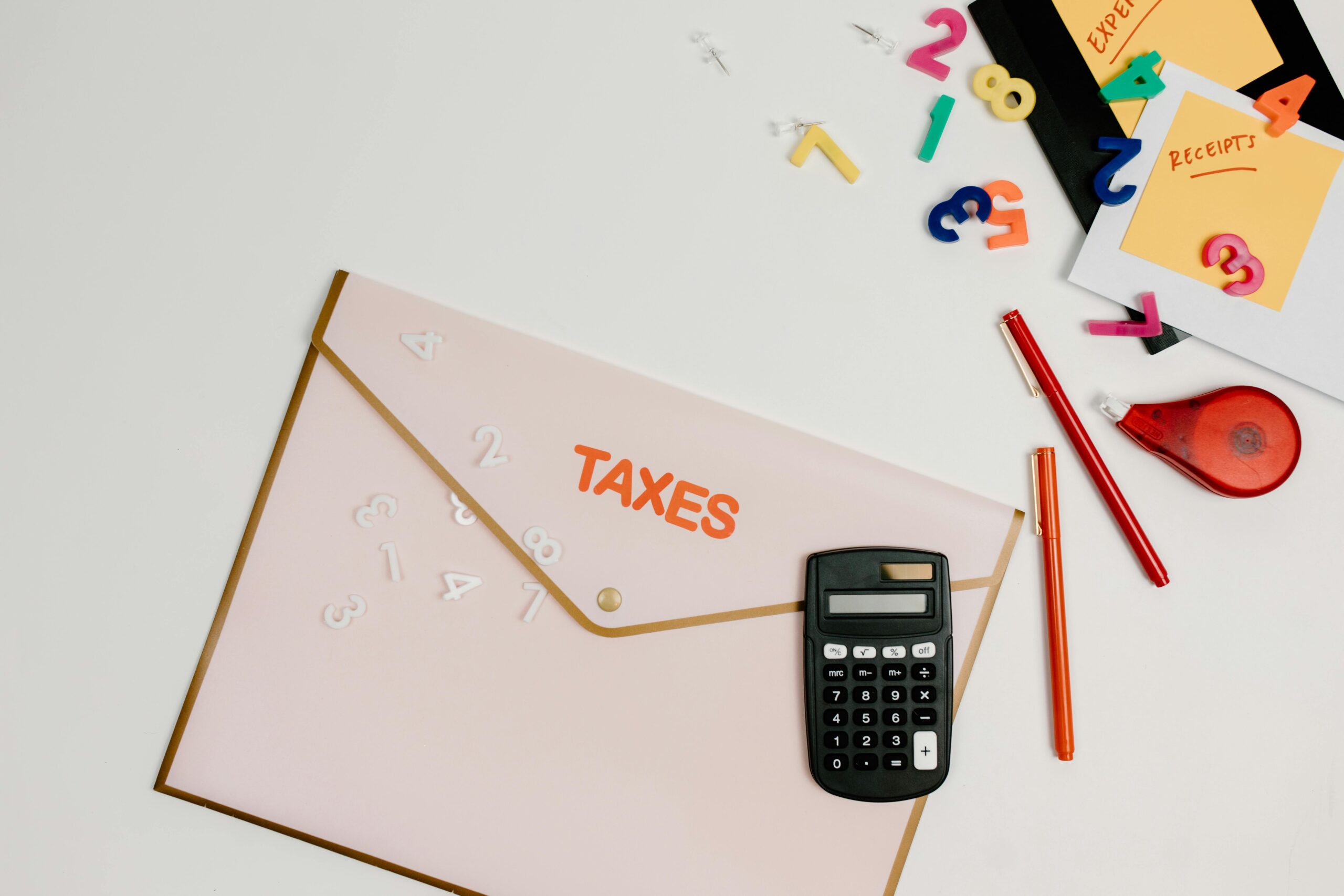 A person using a calculator and reviewing a car loan document, highlighting monthly payment calculations.